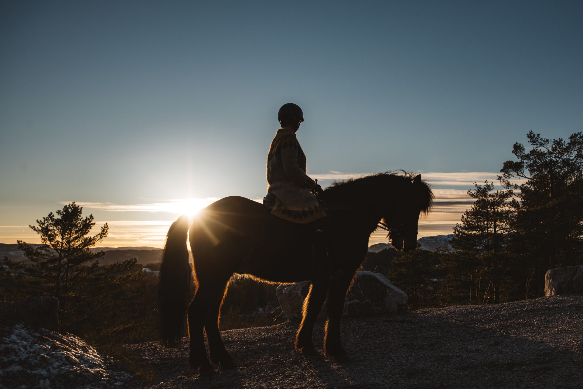 Kvinne på hest i solnedgang